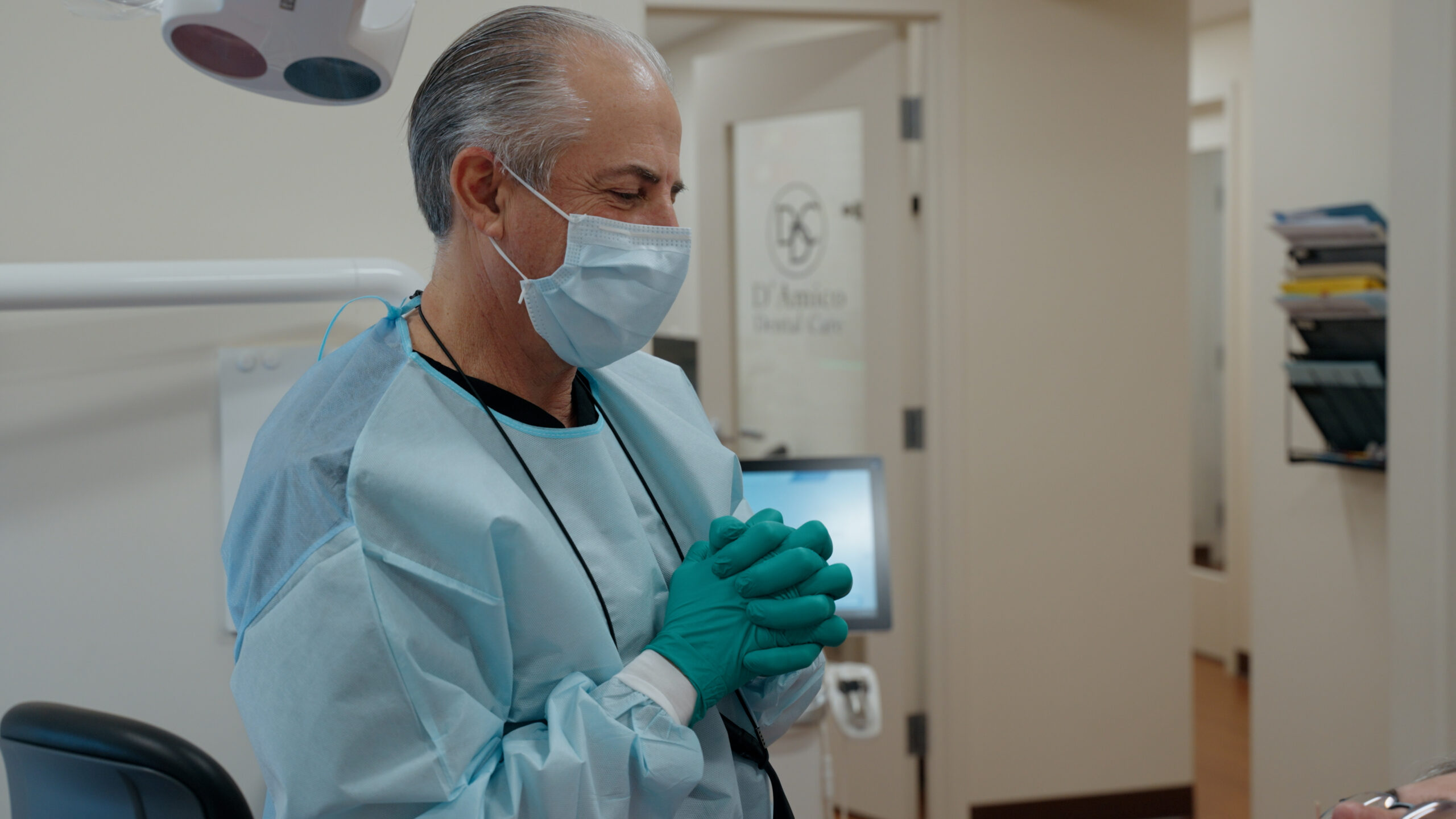 a man in surgical gown and mask with hands together